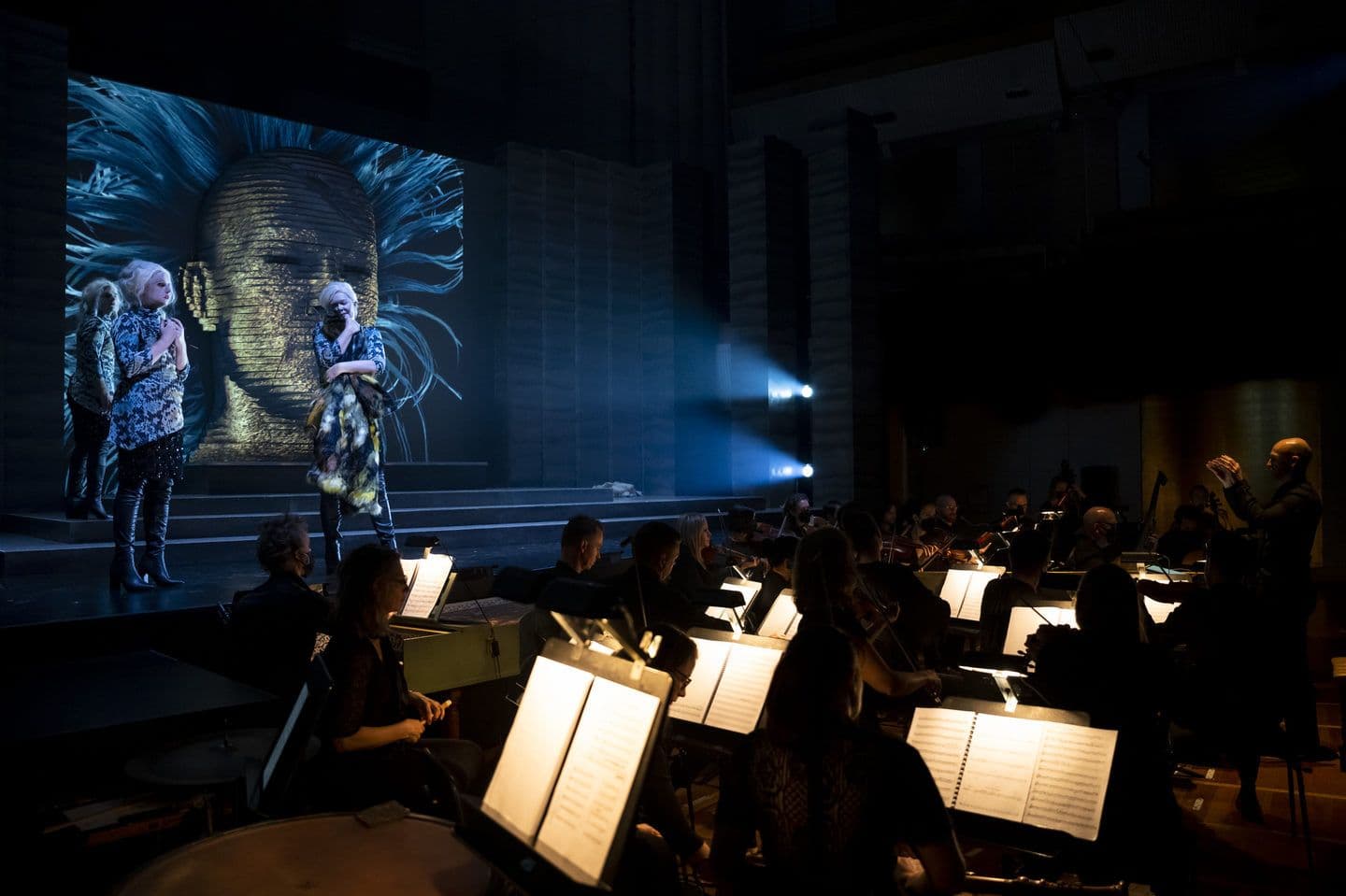 Music Scores from Orchestra of the Antipodes are illuminated by light sconces on music stands in front of the stage at a performance of Pinchgut Opera's Medèe