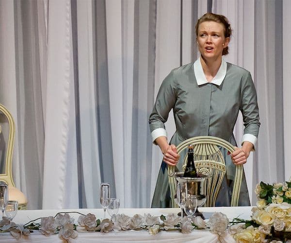 Caitlin Hulcup at a dinner table setting, onstage for Pinchgut's production of Griselda at City Recital Hall
