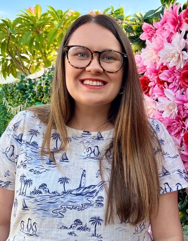 Headshot of Jillian Halleron, a woman, smiling with glasses and long brown hair