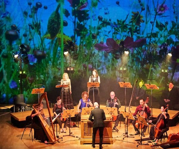 The Orchestra of Antipodes performing Membra Jesu Nostri in front of a floral backdrop at City Recital Hall for Pinchgut Opera