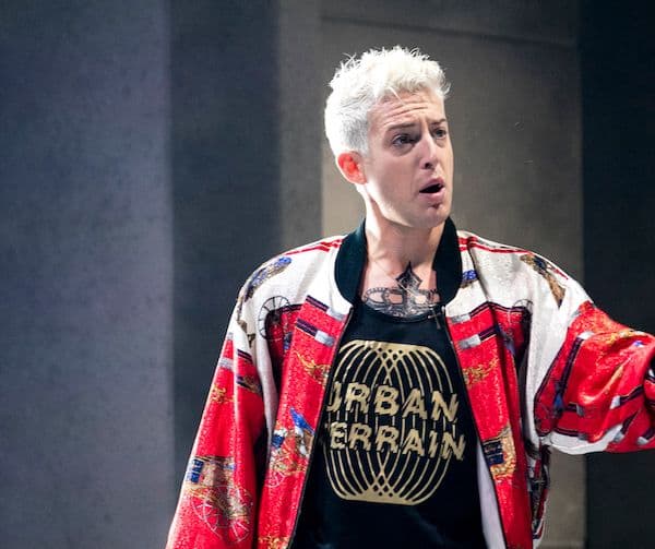 Jake Arditti performing onstage wearing a red jacket as Nero in Pinchgut Opera's performance of Coronation of Poppea.