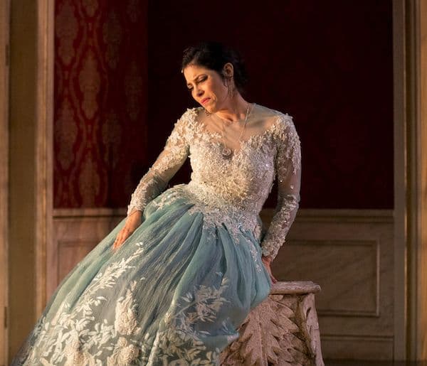 Soprano Vivica Genaux dressed in a dress with white a lacy top and pale blue skirt in a scene from Artaserse
