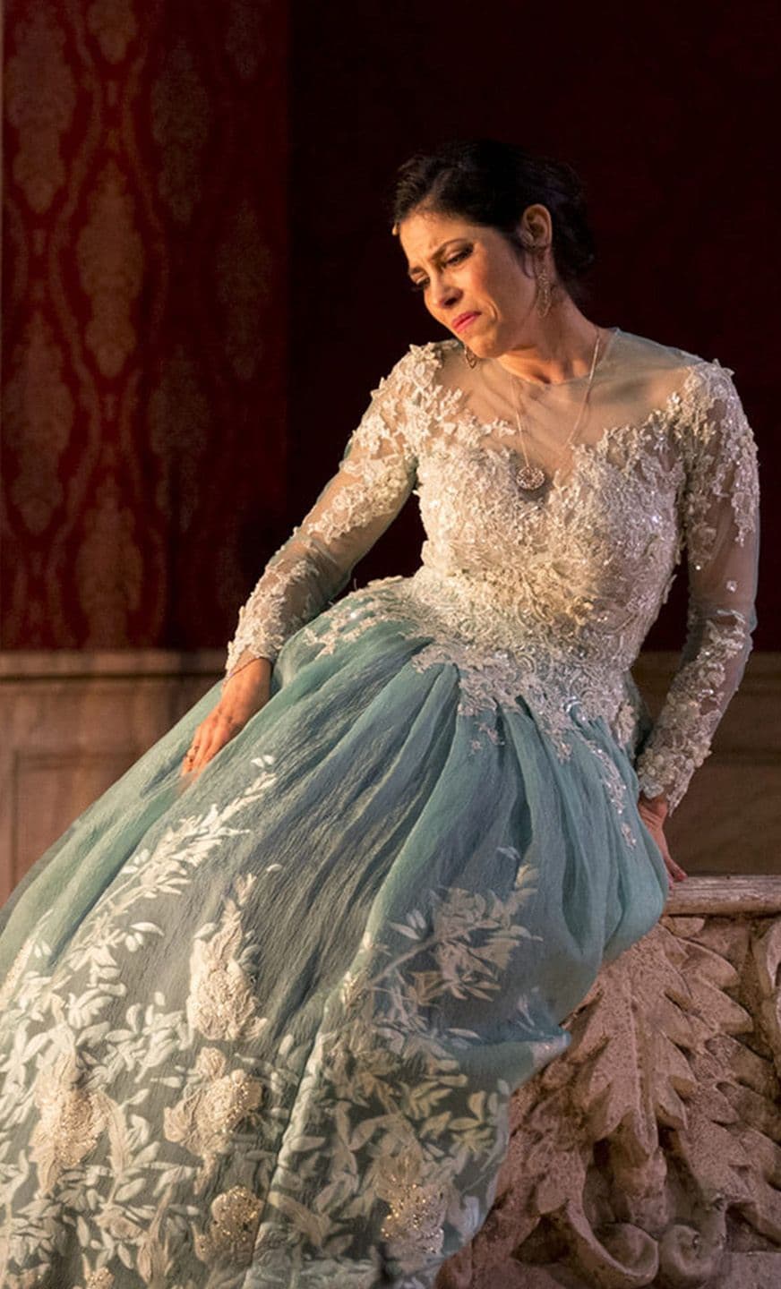 Soprano Vivica Genaux dressed in a dress with white a lacy top and pale blue skirt in a scene from Artaserse